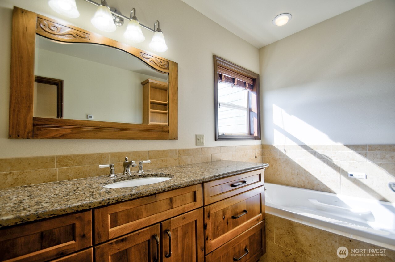 7737 Bordeaux Vista Road Southwest Olympia, WA 98512 - Photo 28 of 38 a bathroom with a granite countertop double vanity sink and mirror