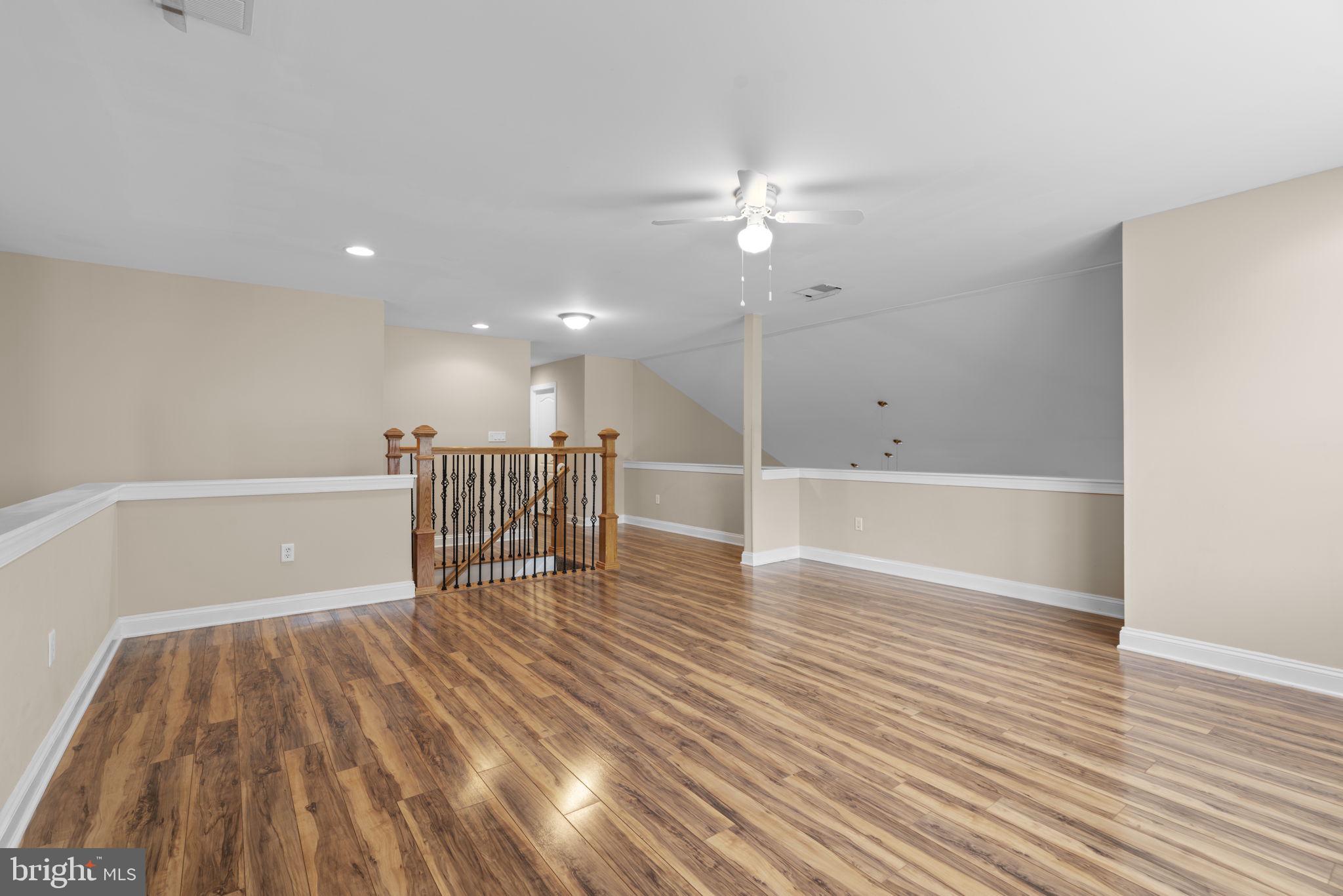 8024 Solley Road Glen Burnie, MD 21060 - Photo 49 of 83 a view of an empty room with wooden floor and a ceiling fan