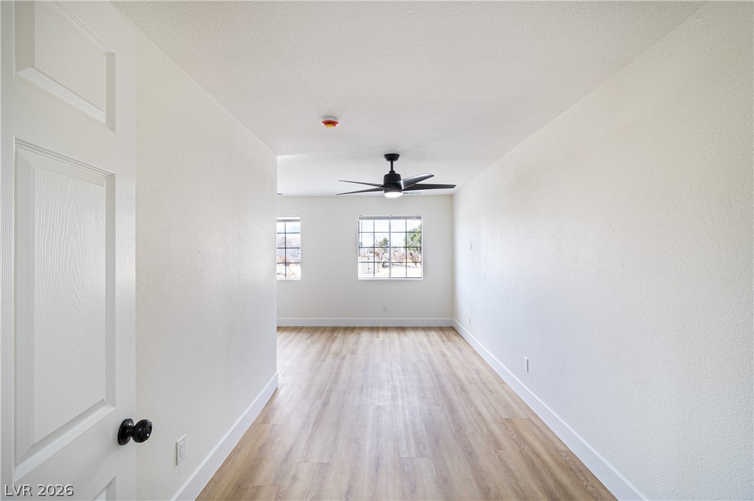 1891 Brian Road Pahrump, NV 89048 - Photo 41 of 50 Empty room with light wood finished floors, a textured ceiling, baseboards, and a ceiling fan