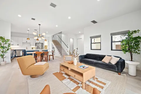 a living room with furniture kitchen view and a large window