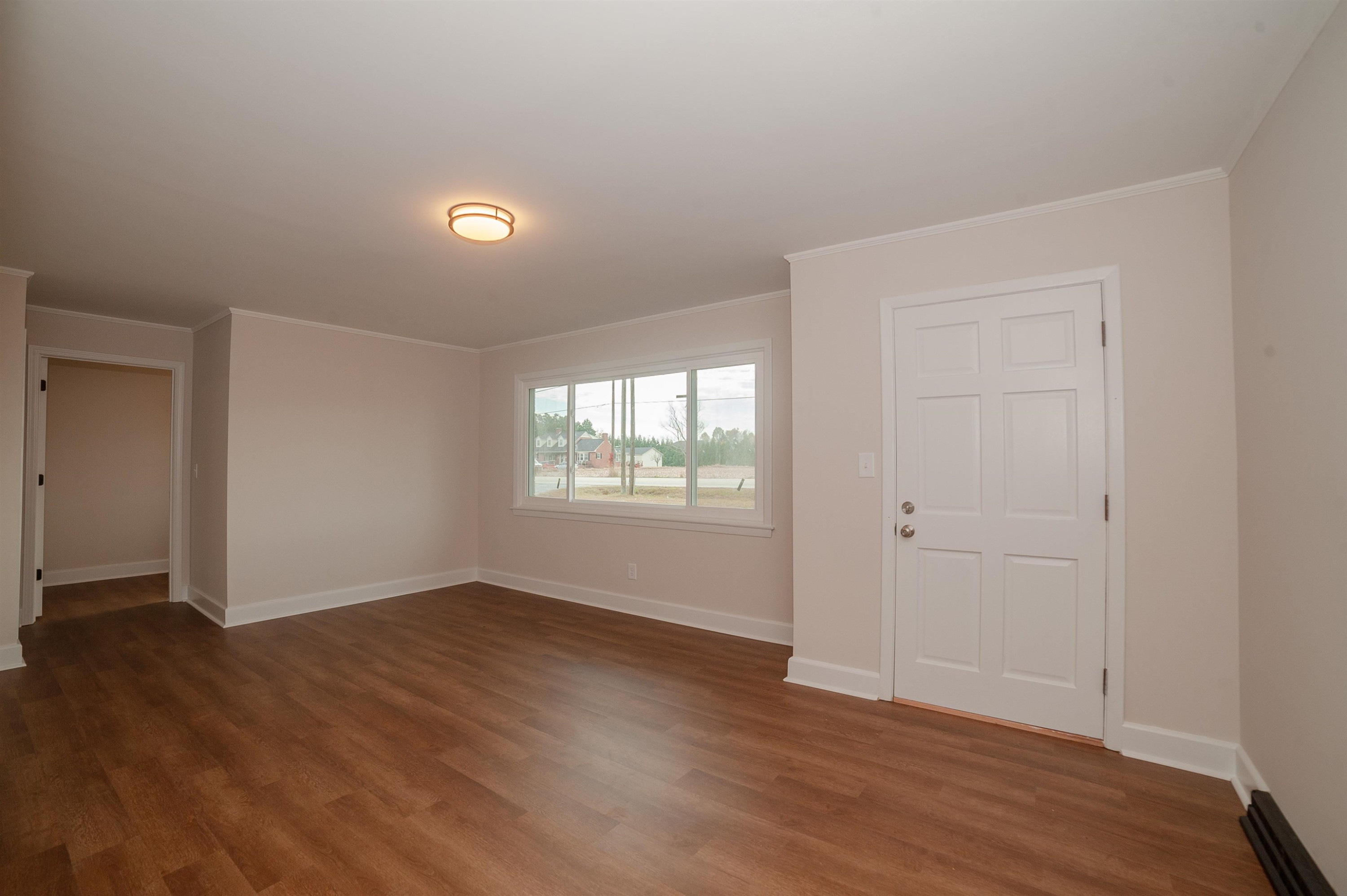 1206 Erwin Road Dunn, NC 28334 - Photo 11 of 24 a view of an empty room with wooden floor and a window