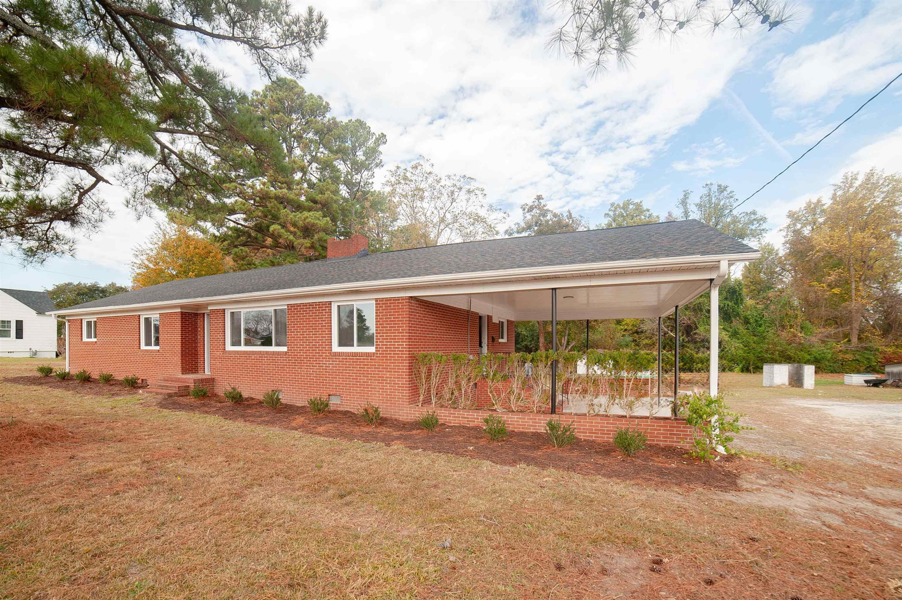 1206 Erwin Road Dunn, NC 28334 - Photo 24 of 24 a view of a house with a backyard and a tree