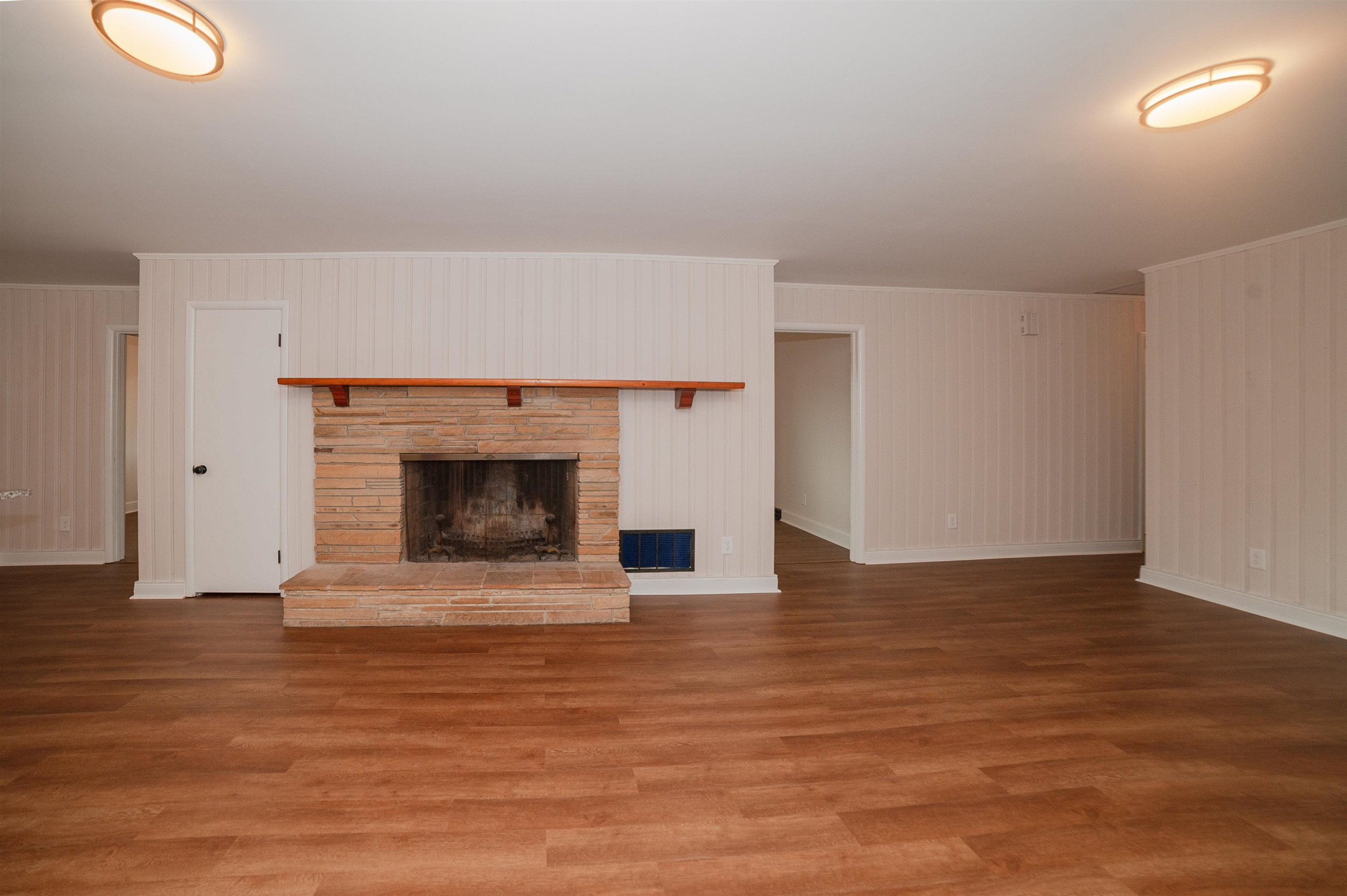 1206 Erwin Road Dunn, NC 28334 - Photo 6 of 24 a view of an empty room with wooden floor and a fireplace