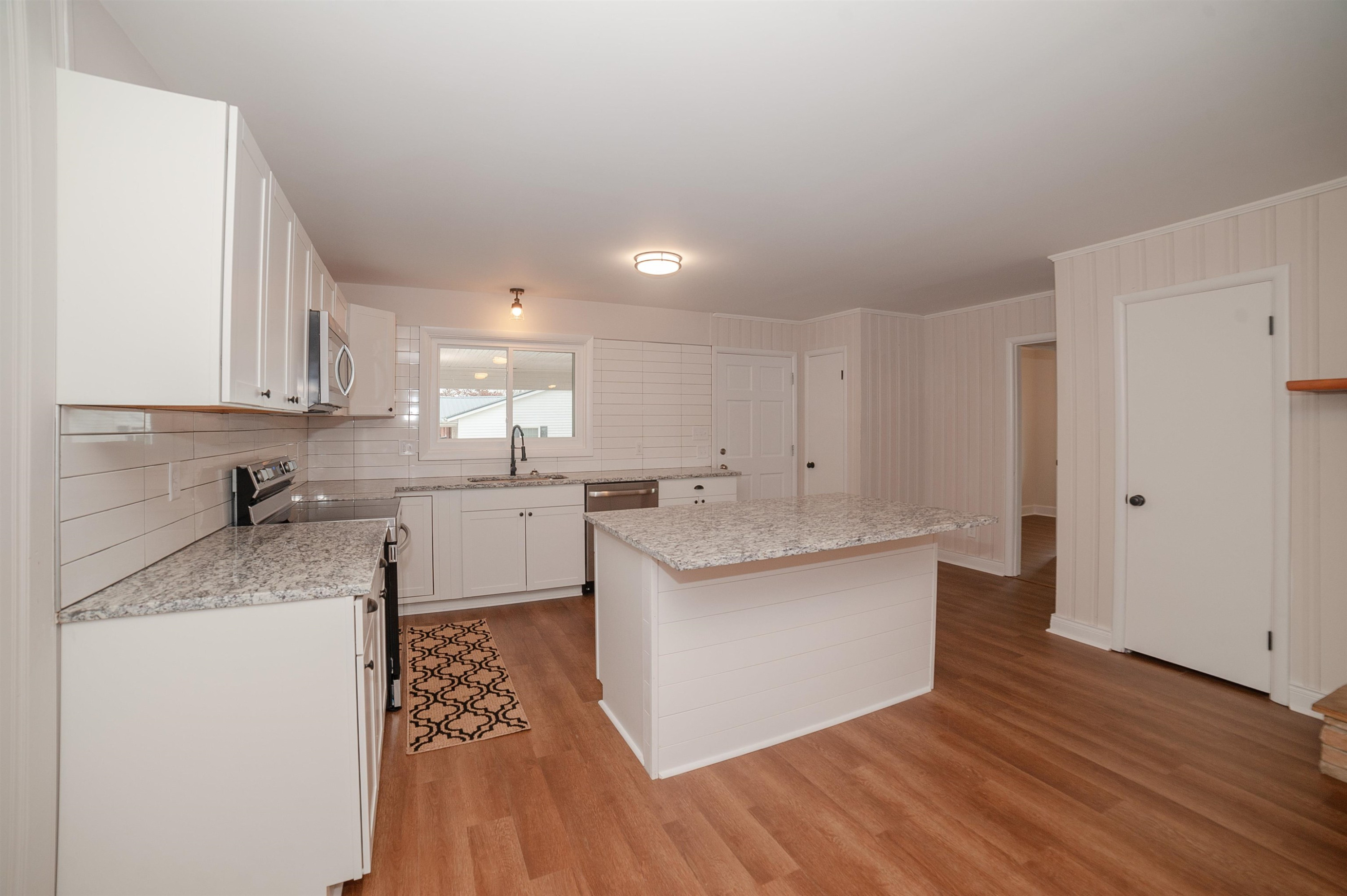 1206 Erwin Road Dunn, NC 28334 - Photo 8 of 24 a kitchen with stainless steel appliances granite countertop a white cabinets and wooden floor