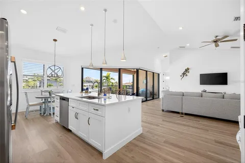a view of kitchen with stainless steel appliances kitchen island granite countertop dining table chairs and a window