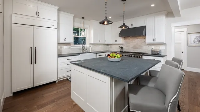 a kitchen with stainless steel appliances granite countertop a sink a stove and a refrigerator