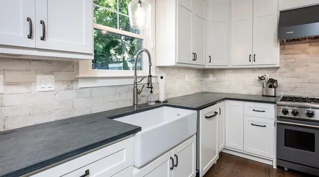 a kitchen with granite countertop a sink and a stove