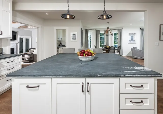 a kitchen with kitchen island granite countertop a counter space and stainless steel appliances