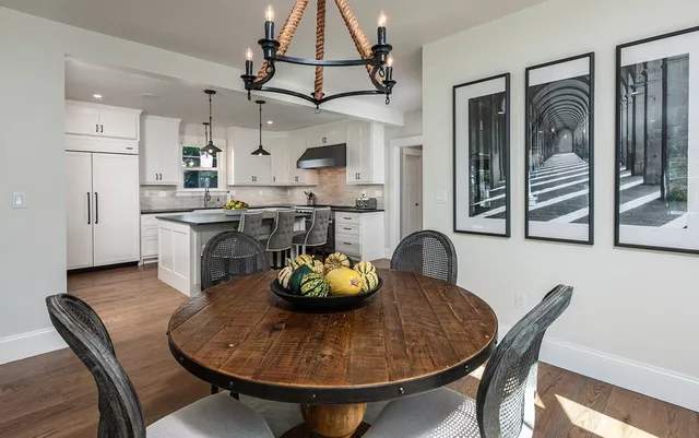 a kitchen with stainless steel appliances granite countertop a dining table and chairs