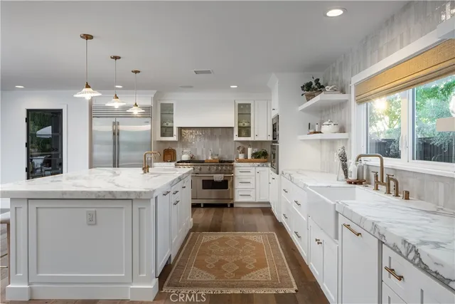 a large kitchen with granite countertop a sink stove and cabinets
