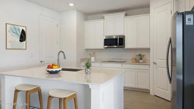 a kitchen with stainless steel appliances a refrigerator sink and microwave