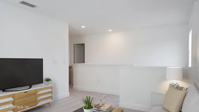 a living room with furniture a chandelier and a dining table