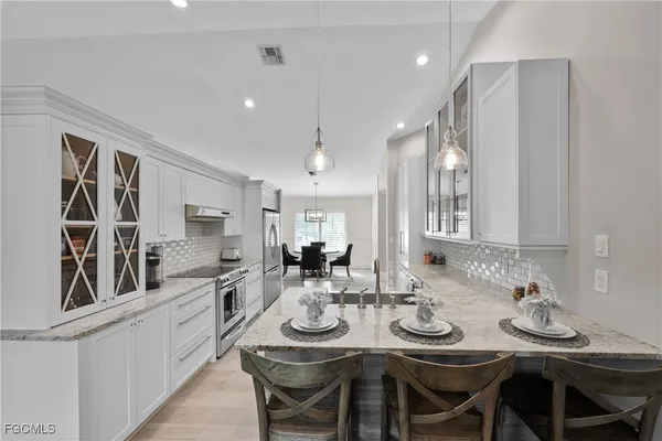 a kitchen with kitchen island granite countertop a sink and refrigerator