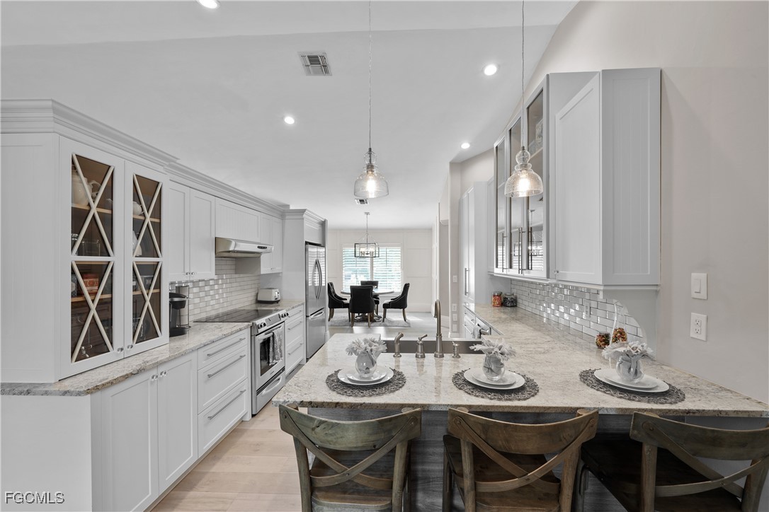 2003 Timberline Drive Naples, FL 34109 - Photo 23 of 44 a kitchen with kitchen island granite countertop a sink and refrigerator