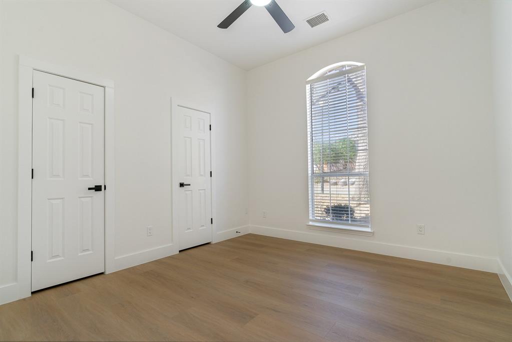 7524 Aberdon Road Dallas, TX 75252 - Photo 18 of 39 Empty room featuring visible vents, plenty of natural light, baseboards, and wood finished floors