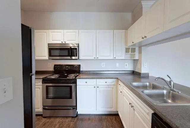 a kitchen with stainless steel appliances granite countertop a stove microwave and sink