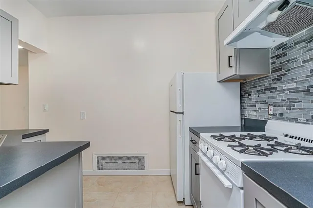 a stove top oven sitting inside of a kitchen