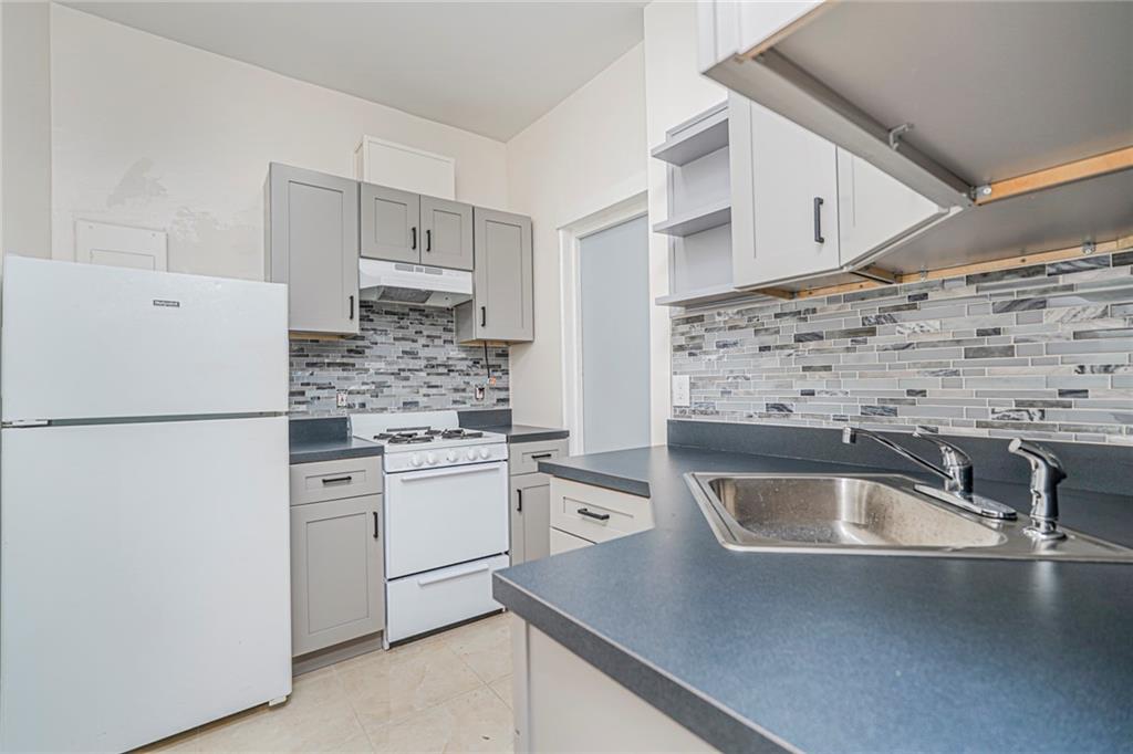 217 Brighton 1st Lane Brooklyn, NY 11235 - Photo 13 of 24 a kitchen with a refrigerator sink and stove