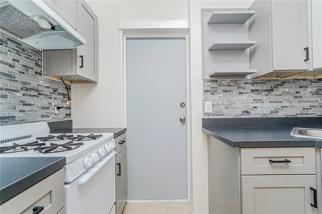 a kitchen with granite countertop a stove and a sink