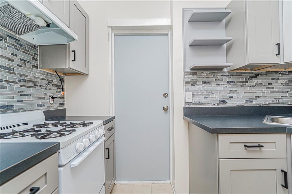 217 Brighton 1st Lane Brooklyn, NY 11235 - Photo 15 of 24 a kitchen with granite countertop a stove and a sink