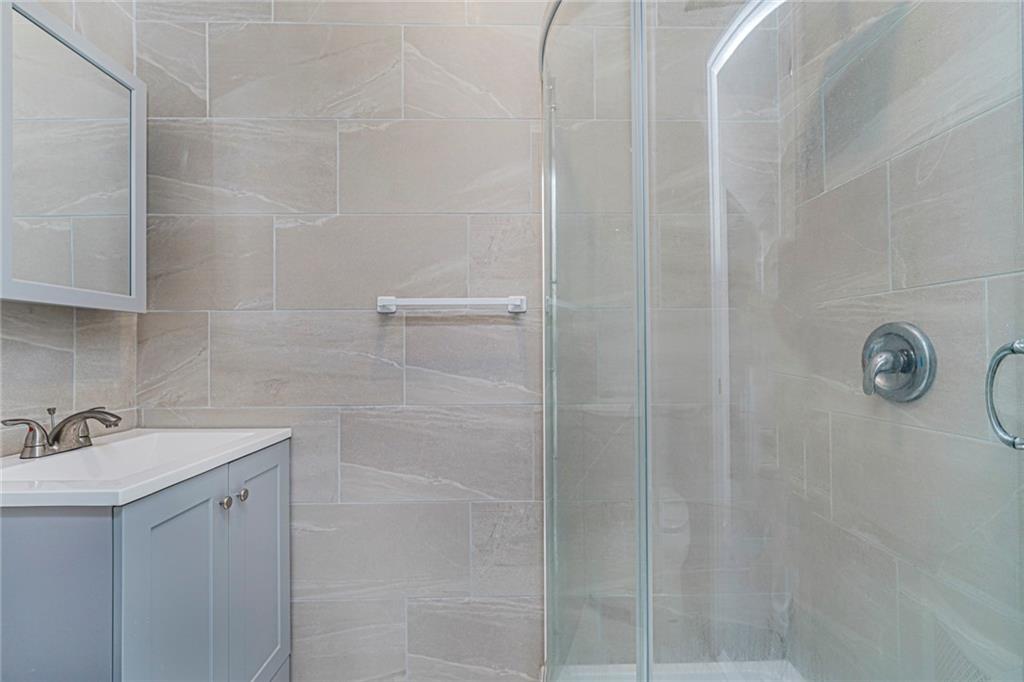 217 Brighton 1st Lane Brooklyn, NY 11235 - Photo 16 of 24 a bathroom with a shower and sink