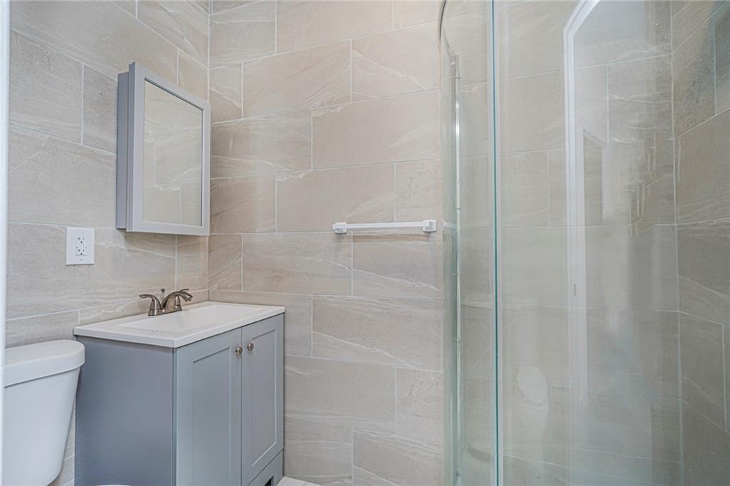 217 Brighton 1st Lane Brooklyn, NY 11235 - Photo 17 of 24 a bathroom with a sink and a mirror