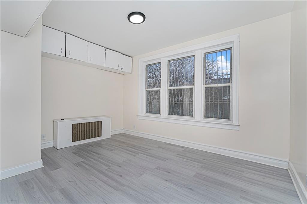217 Brighton 1st Lane Brooklyn, NY 11235 - Photo 19 of 24 a view of an empty room with wooden floor and a window