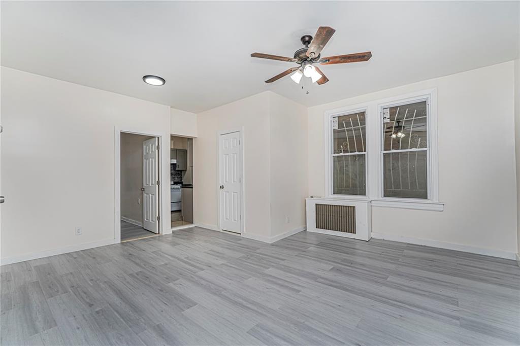 217 Brighton 1st Lane Brooklyn, NY 11235 - Photo 10 of 24 a view of an empty room with wooden floor and a window