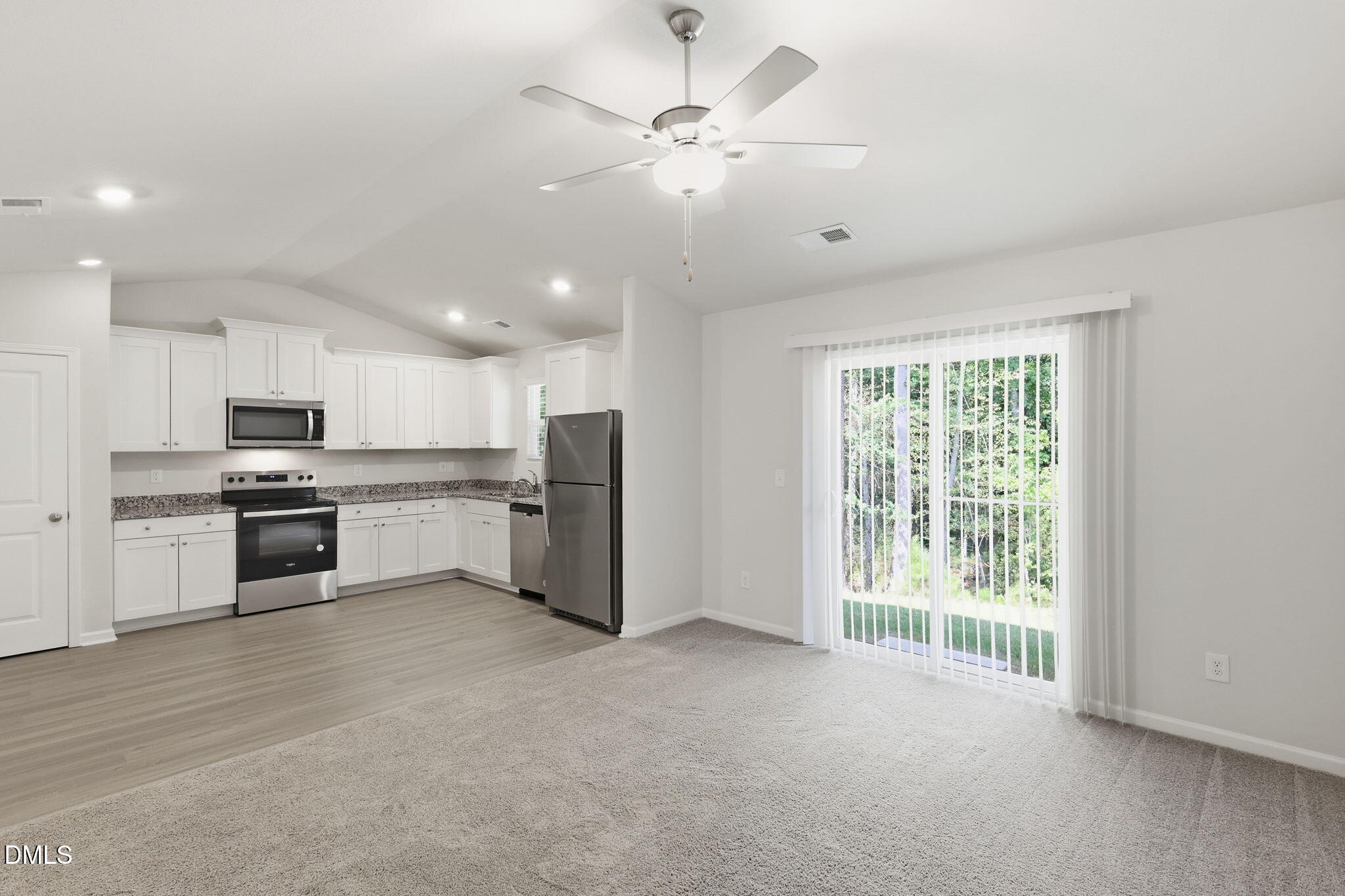 90 Everglade Way Angier, NC 27501 - Photo 9 of 36 a open kitchen with stainless steel appliances kitchen island granite countertop a stove top oven a sink and a refrigerator with wooden floor