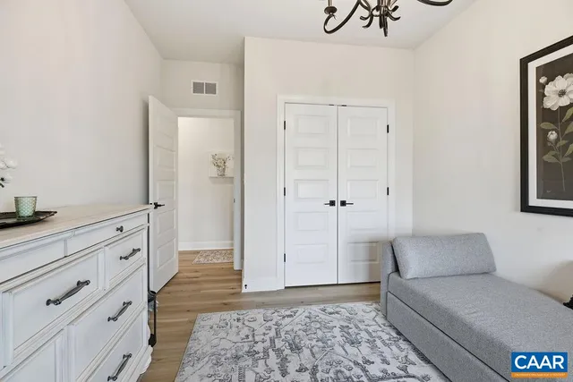a bedroom with a bed a flat screen tv and dresser