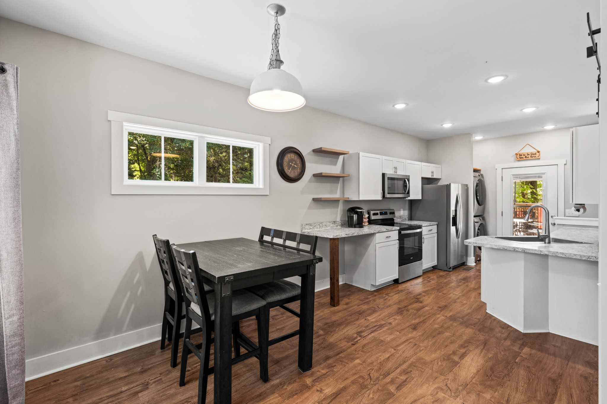 115 North Adams Street Adams, TN 37010 - Photo 11 of 44 a kitchen with stainless steel appliances kitchen island granite countertop a stove top oven a sink a dining table and chairs with wooden floor