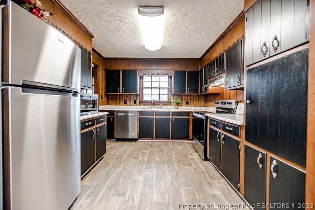 634 Richmond Road Rockingham, NC 28379 - Photo 11 of 40 a kitchen with stainless steel appliances granite countertop a stove top oven a sink and a refrigerator