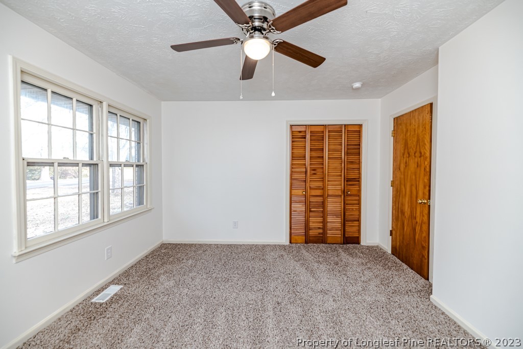 634 Richmond Road Rockingham, NC 28379 - Photo 23 of 40 a view of an empty room with a window and a ceiling fan