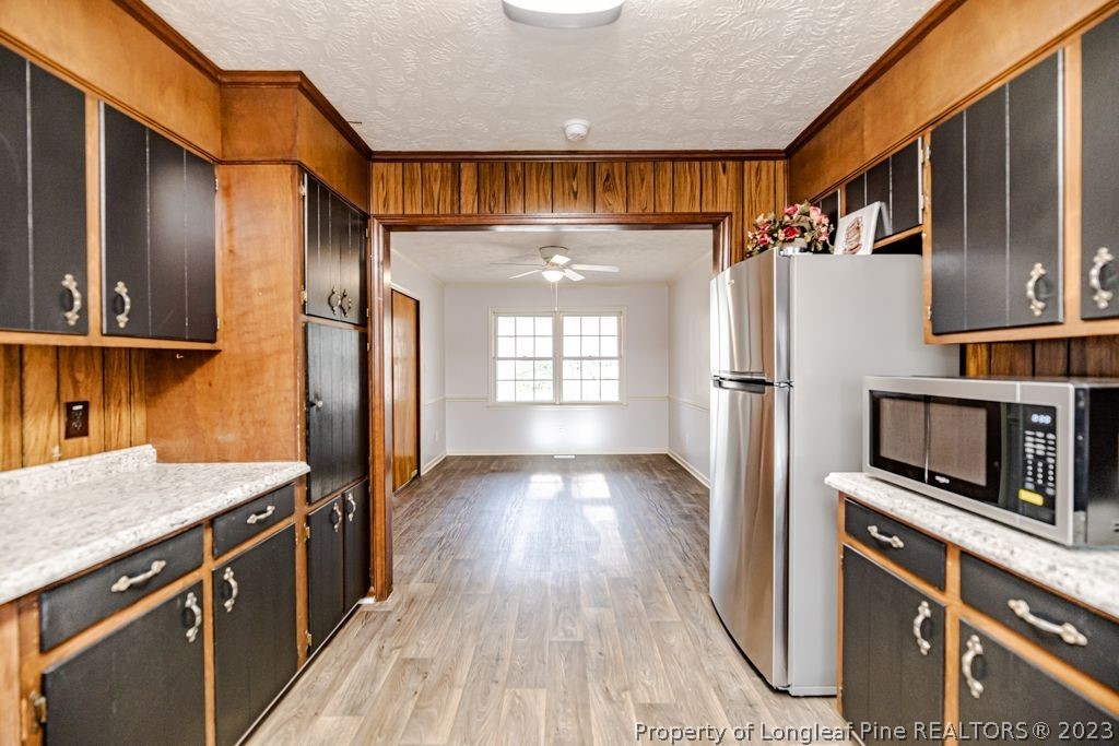 634 Richmond Road Rockingham, NC 28379 - Photo 9 of 40 a kitchen with stainless steel appliances a refrigerator and a wooden cabinets