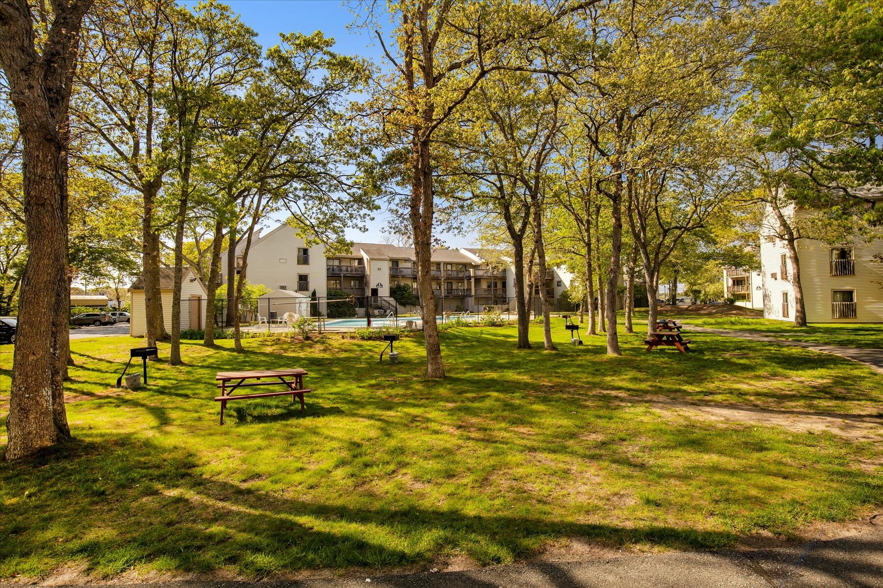 800 Bearses Way, Unit 1EB Hyannis, MA 02601 - Photo 26 of 37 a view of swimming pool with trees and wooden fence