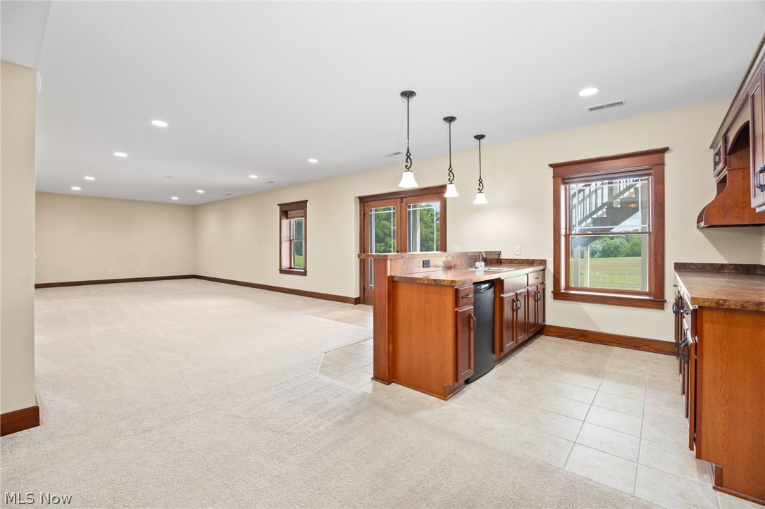 6925 River Styx Road Medina, OH 44256 - Photo 35 of 49 Expansive lower level featuring a wet bar with integrated mini-refrigerator, recessed lighting, and direct outdoor access through French doors