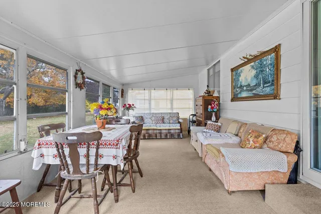 a dining room with furniture and a large window