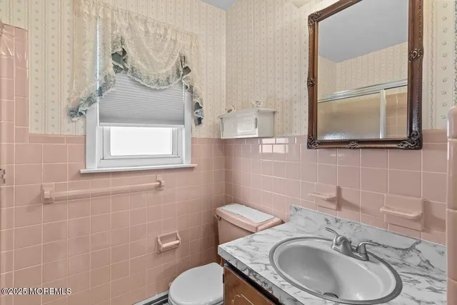 a bathroom with a toilet sink and mirror