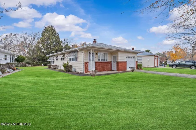 a view of a house with a big yard and large trees