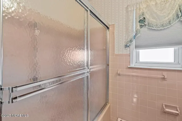 a bathroom with a glass shower door and a mirror