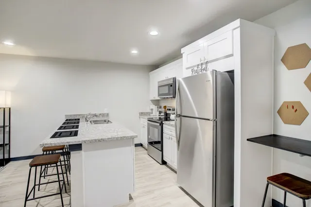 a kitchen with a refrigerator a stove and a dining table