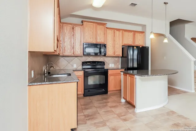a kitchen with stainless steel appliances granite countertop a stove a sink and a refrigerator