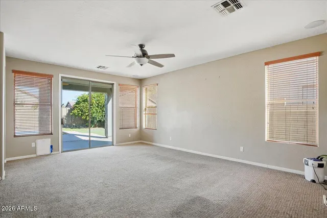 an empty room with windows and fan