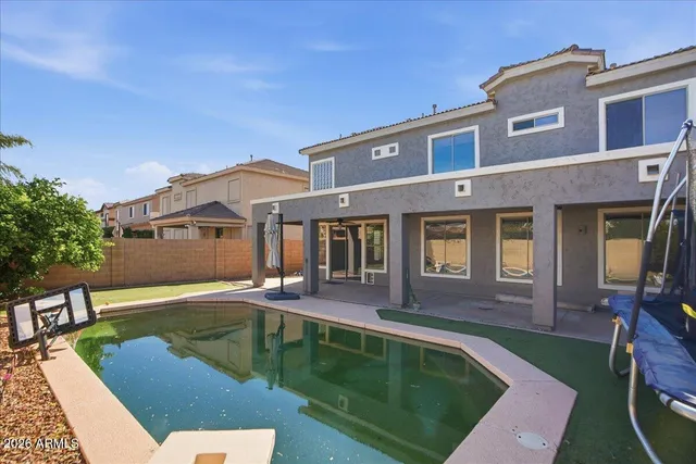 a front view of a house with swimming pool having outdoor seating