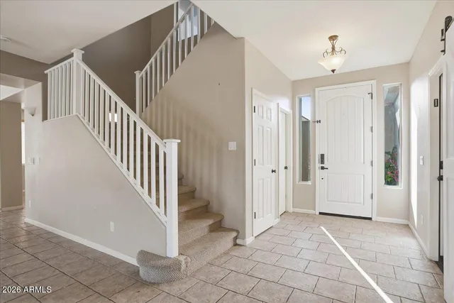 a view of an empty room with wooden floor and a ceiling fan