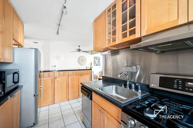 a kitchen with stainless steel appliances granite countertop a sink a stove and chairs