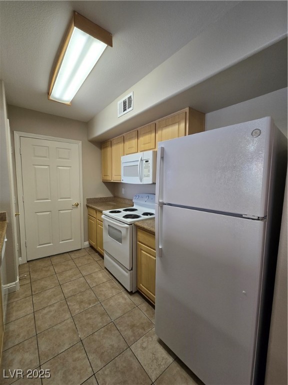 8000 West Badura Avenue, Unit 2135 Las Vegas, NV 89113 - Photo 13 of 28 Kitchen with white appliances, light brown cabinetry, light tile patterned floors, and light countertops