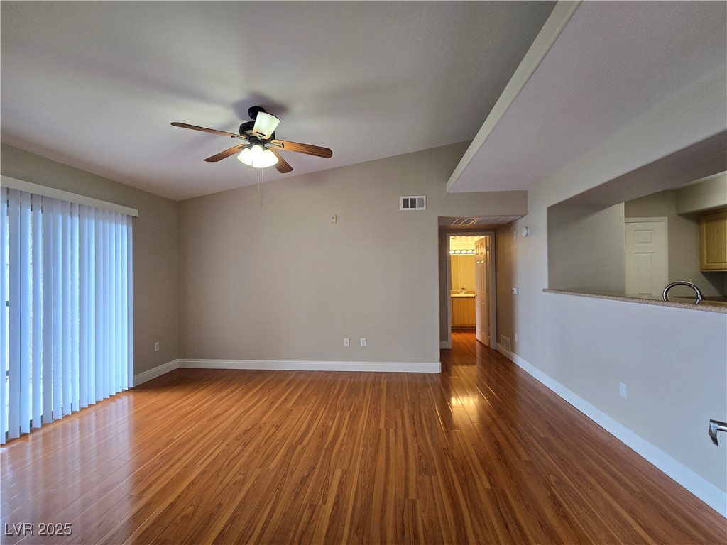 8000 West Badura Avenue, Unit 2135 Las Vegas, NV 89113 - Photo 3 of 28 Empty room featuring dark wood finished floors, vaulted ceiling, and ceiling fan