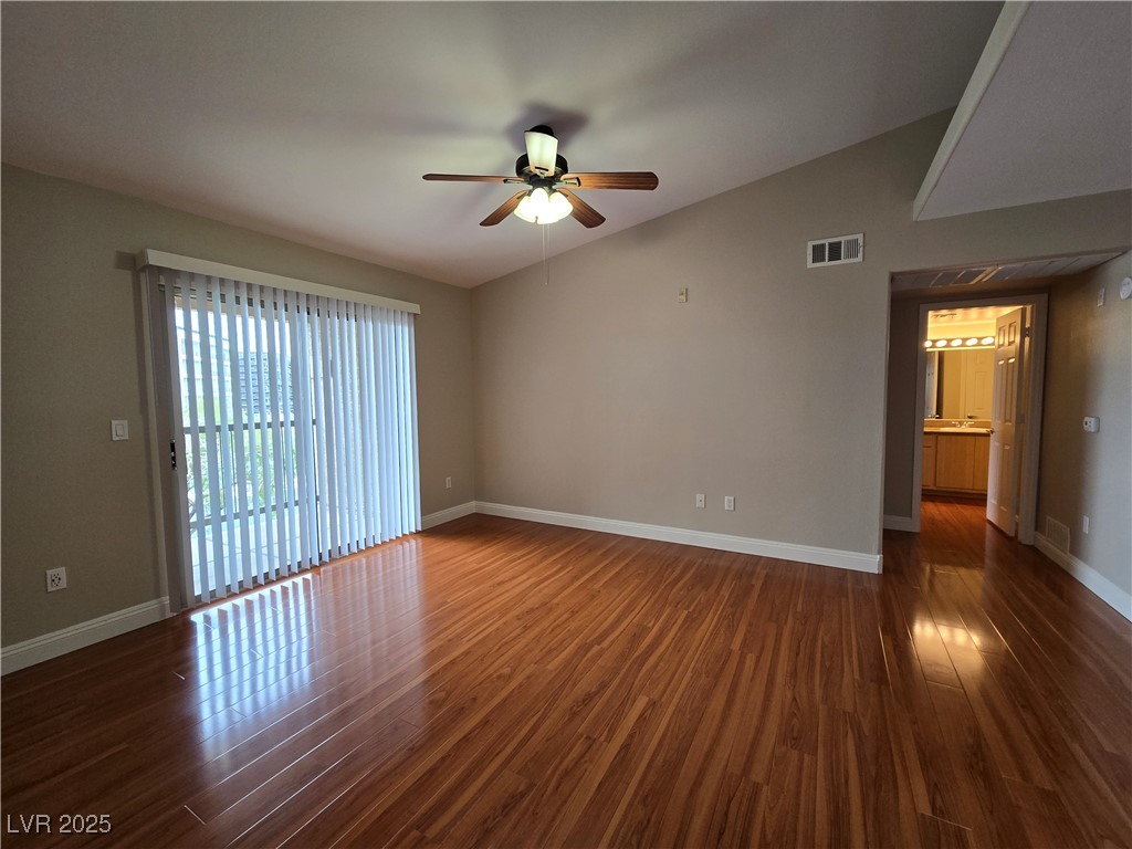 8000 West Badura Avenue, Unit 2135 Las Vegas, NV 89113 - Photo 4 of 28 Unfurnished room featuring vaulted ceiling, dark wood finished floors, and a ceiling fan