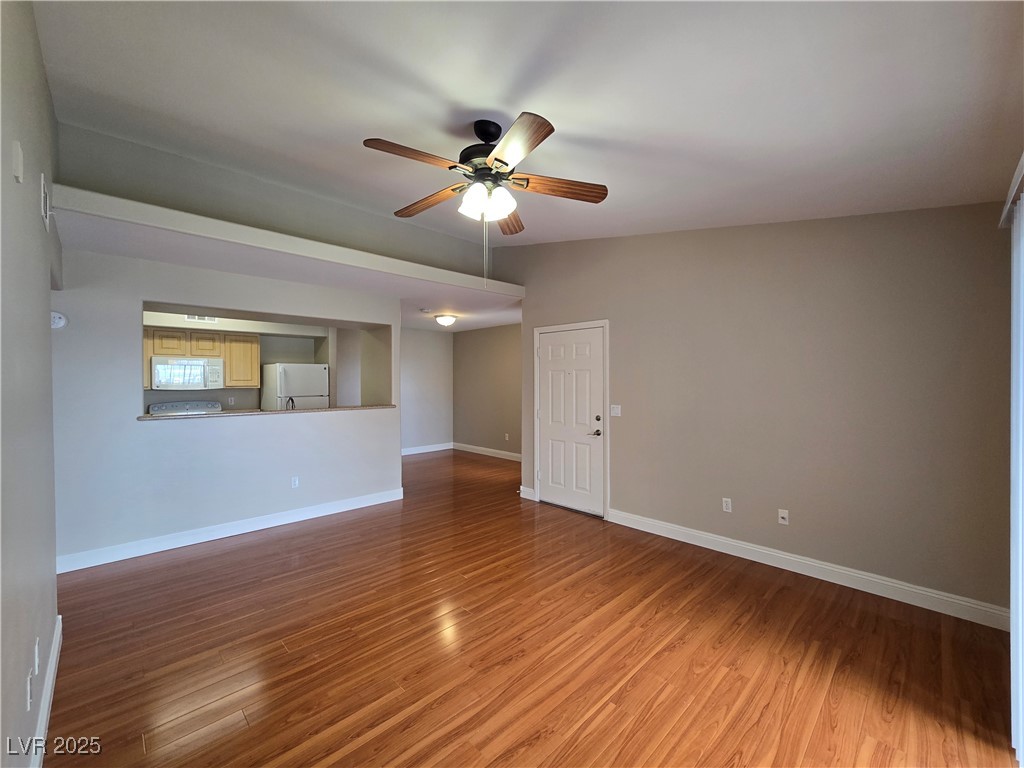 8000 West Badura Avenue, Unit 2135 Las Vegas, NV 89113 - Photo 7 of 28 Empty room with light wood finished floors and ceiling fan